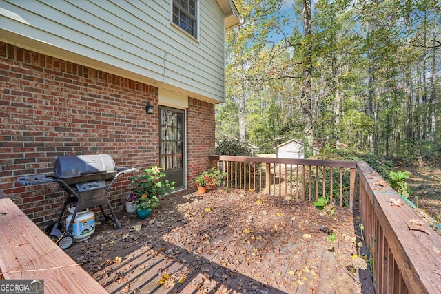 wooden deck with an outbuilding and a grill