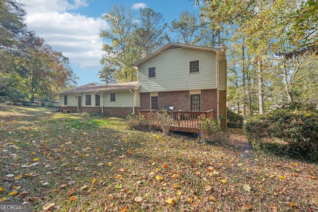 rear view of house featuring a wooden deck