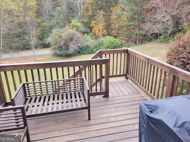 wooden terrace with a grill and a yard