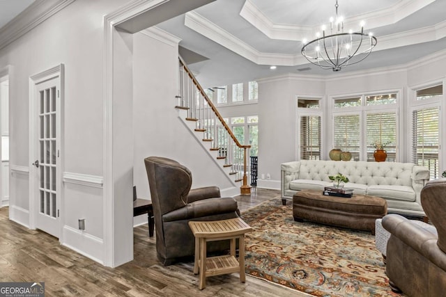 living room featuring a tray ceiling, crown molding, and hardwood / wood-style floors