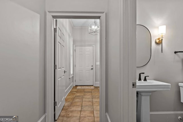 bathroom with ornamental molding, toilet, and a notable chandelier