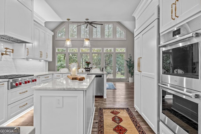 kitchen with ceiling fan, white cabinetry, a center island, and appliances with stainless steel finishes