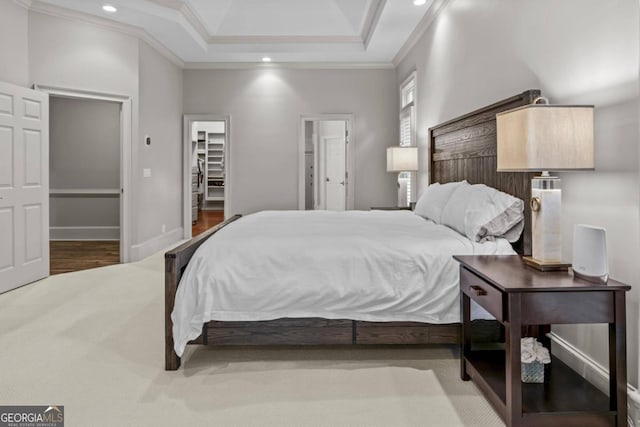 bedroom featuring a walk in closet, crown molding, a closet, and wood-type flooring