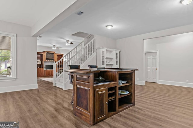 kitchen featuring ceiling fan, hardwood / wood-style floors, a kitchen island, and dark brown cabinets