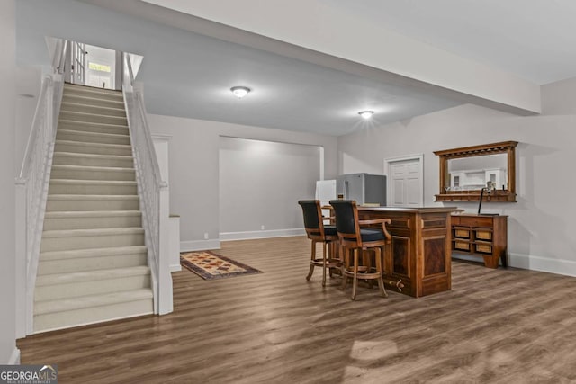 interior space featuring stainless steel fridge and dark hardwood / wood-style floors