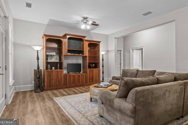 living room with light hardwood / wood-style floors and ceiling fan