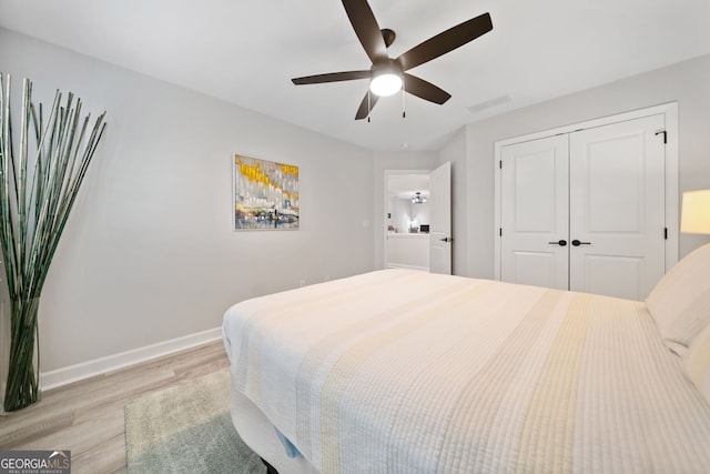 bedroom featuring light hardwood / wood-style floors, ceiling fan, and a closet