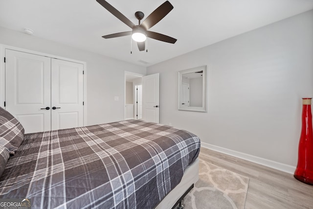 bedroom featuring light hardwood / wood-style flooring, a closet, and ceiling fan