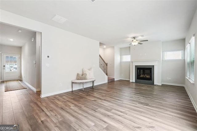 unfurnished living room featuring ceiling fan, plenty of natural light, and light hardwood / wood-style floors