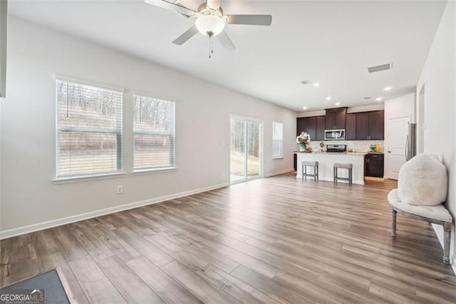 living room with ceiling fan and light wood-type flooring