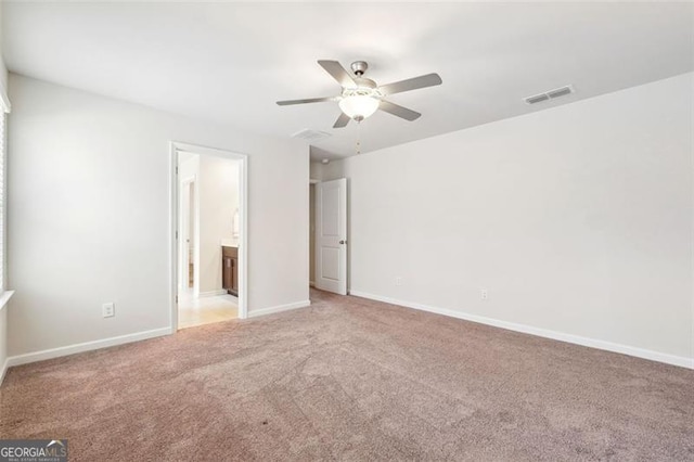 unfurnished bedroom with ensuite bath, ceiling fan, and light carpet