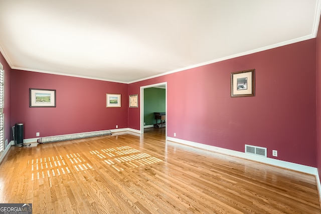 spare room featuring a baseboard radiator, hardwood / wood-style flooring, and crown molding