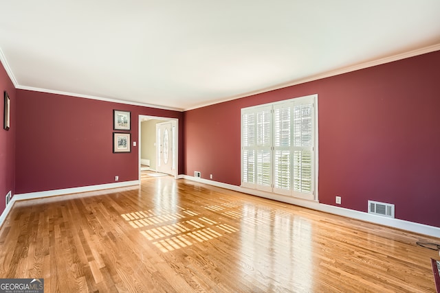 spare room featuring crown molding and hardwood / wood-style floors