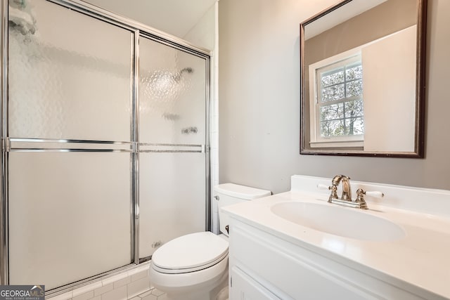 bathroom with vanity, toilet, tile patterned floors, and a shower with door