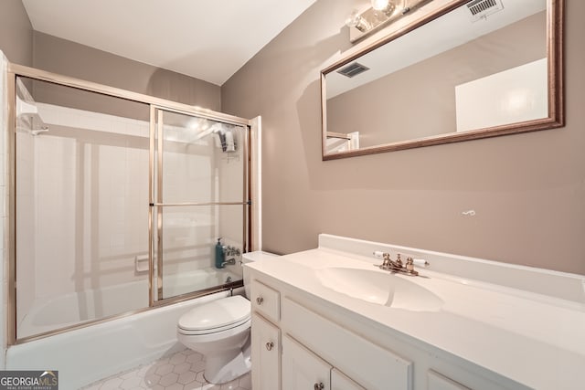 full bathroom featuring combined bath / shower with glass door, tile patterned floors, vanity, and toilet