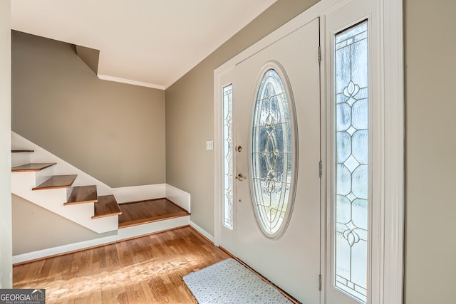 foyer entrance featuring light hardwood / wood-style floors and ornamental molding