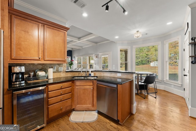 kitchen with kitchen peninsula, stainless steel dishwasher, beverage cooler, sink, and light hardwood / wood-style flooring