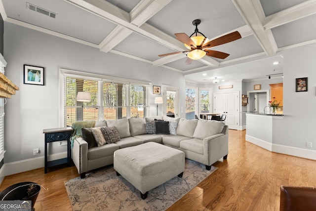 living room with plenty of natural light, light wood-type flooring, and coffered ceiling