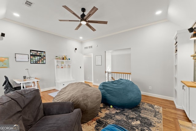 living room with light hardwood / wood-style floors, vaulted ceiling, ceiling fan, and crown molding