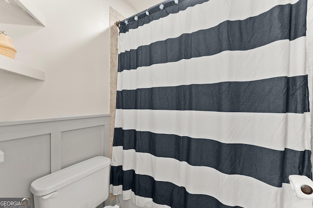 bathroom with a shower with curtain and toilet