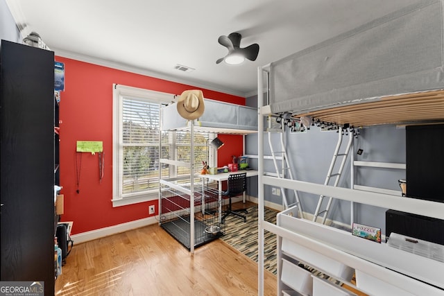 bedroom with wood-type flooring, ceiling fan, and ornamental molding