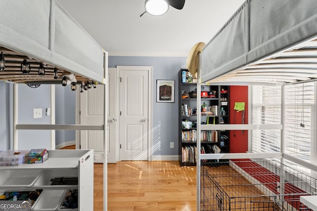 interior space with hardwood / wood-style flooring, ceiling fan, and ornamental molding