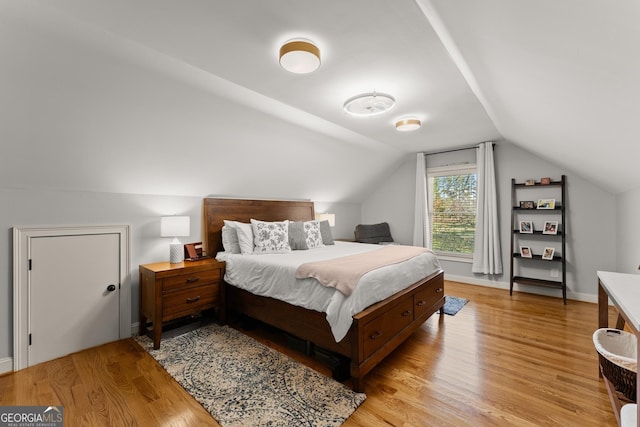 bedroom featuring vaulted ceiling and light hardwood / wood-style flooring