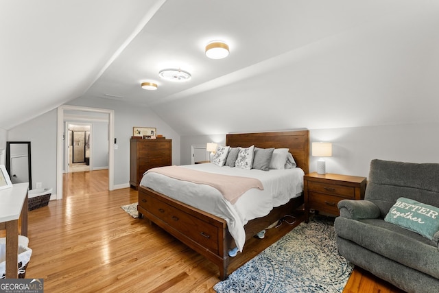 bedroom with light wood-type flooring and lofted ceiling