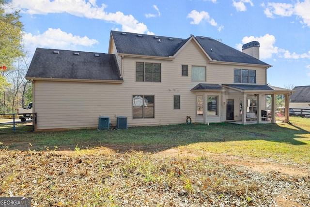 rear view of house featuring a yard, central AC unit, and a patio area