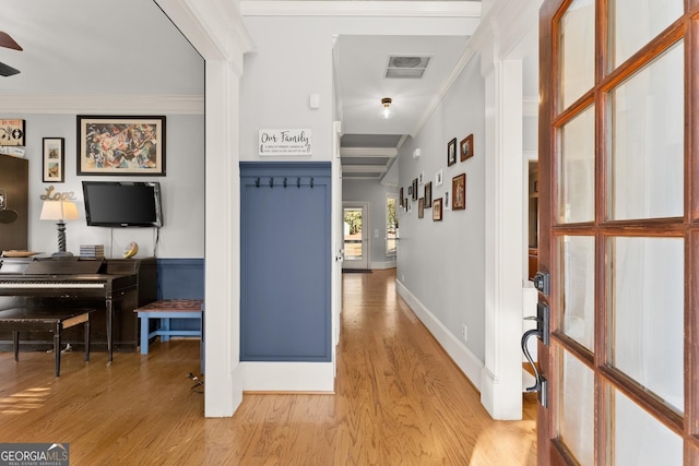 hallway with light hardwood / wood-style floors and crown molding