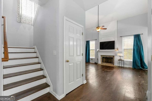 staircase with wood-type flooring, plenty of natural light, a high ceiling, and ceiling fan