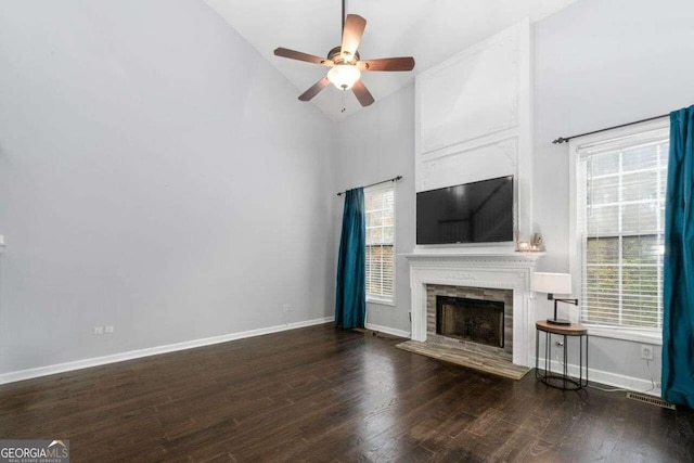 unfurnished living room featuring dark wood-type flooring, a fireplace, and a healthy amount of sunlight