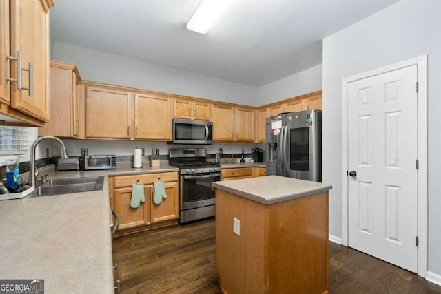 kitchen with appliances with stainless steel finishes, a center island, dark wood-type flooring, and sink