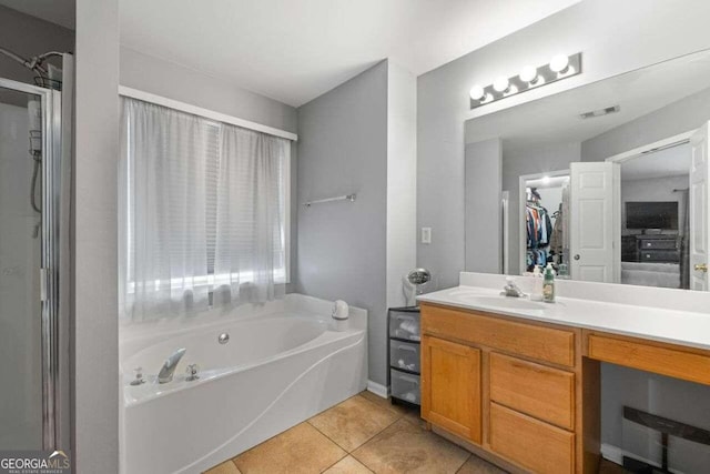 bathroom with tile patterned flooring, vanity, and a bathing tub