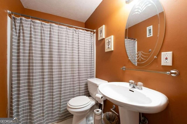 bathroom with sink, a textured ceiling, and toilet