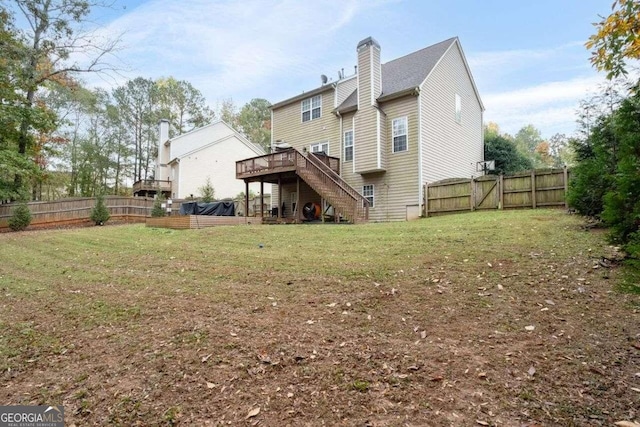 rear view of property with a yard and a wooden deck