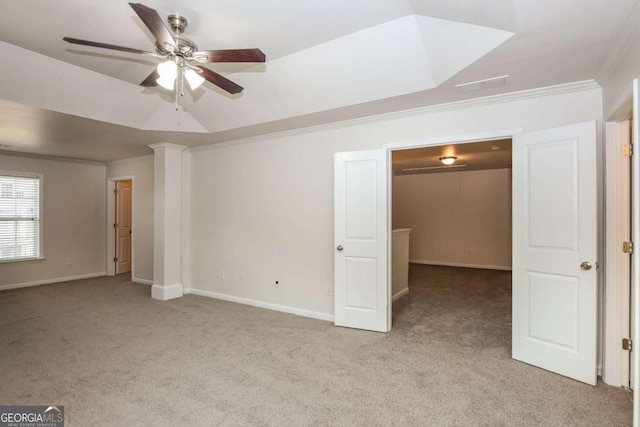 carpeted empty room with decorative columns, ceiling fan, and crown molding