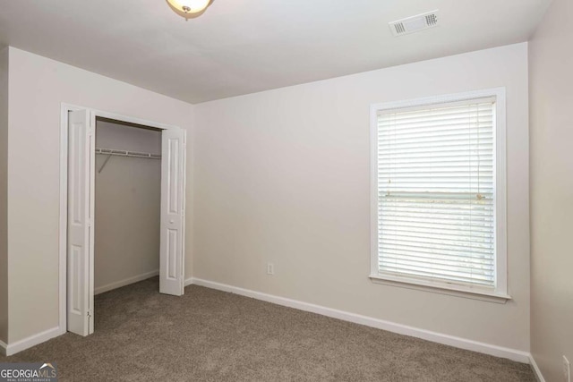 unfurnished bedroom featuring carpet flooring and a closet