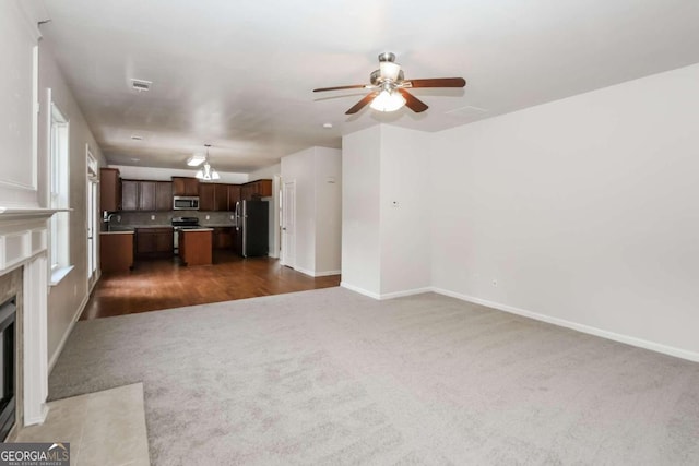 unfurnished living room with ceiling fan and dark wood-type flooring