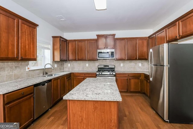 kitchen featuring sink, a kitchen island, dark hardwood / wood-style floors, and appliances with stainless steel finishes