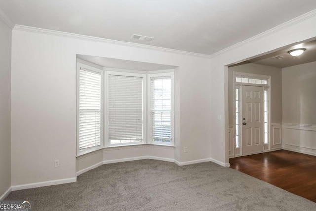 carpeted foyer with ornamental molding