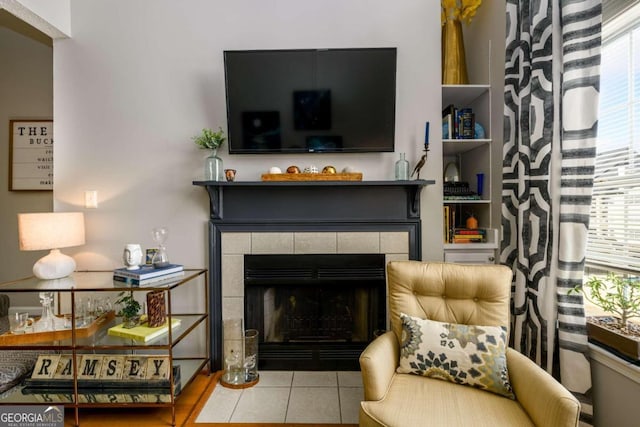 living room with plenty of natural light, light tile patterned flooring, and a tile fireplace