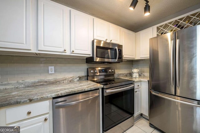 kitchen with white cabinets, light tile patterned floors, a textured ceiling, and appliances with stainless steel finishes