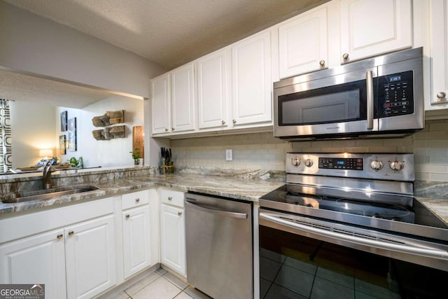 kitchen featuring white cabinetry, sink, stainless steel appliances, and a textured ceiling