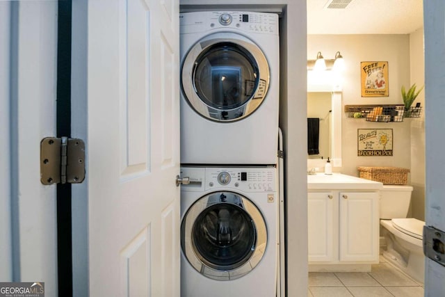 laundry room with light tile patterned floors and stacked washer and clothes dryer