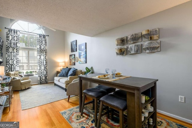 dining space featuring a textured ceiling and hardwood / wood-style flooring