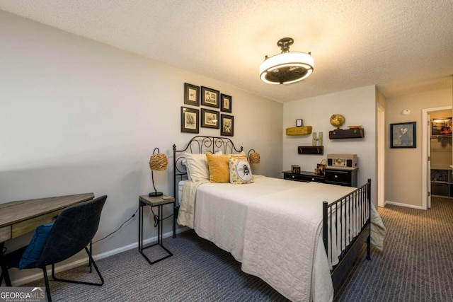 carpeted bedroom with a textured ceiling, a spacious closet, and a closet