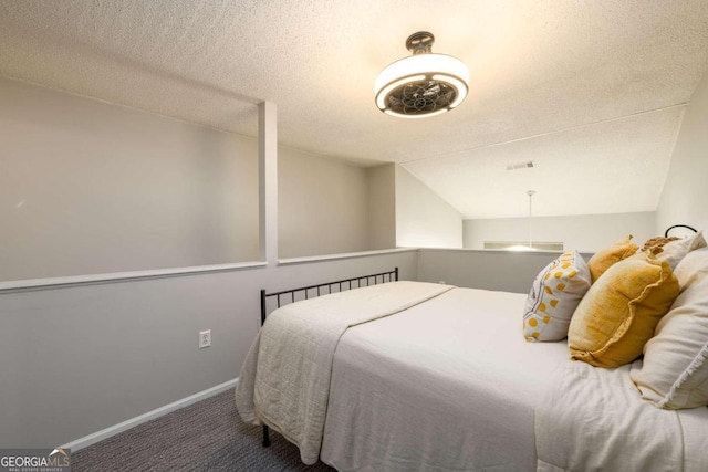 bedroom with a textured ceiling, carpet, and vaulted ceiling