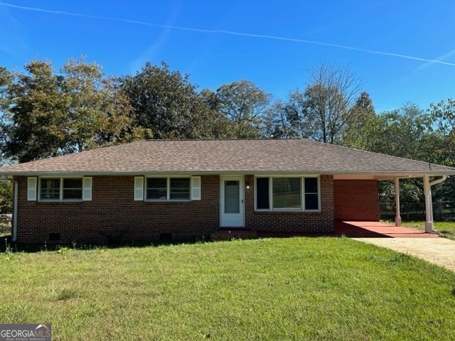 ranch-style home with a front lawn and a carport