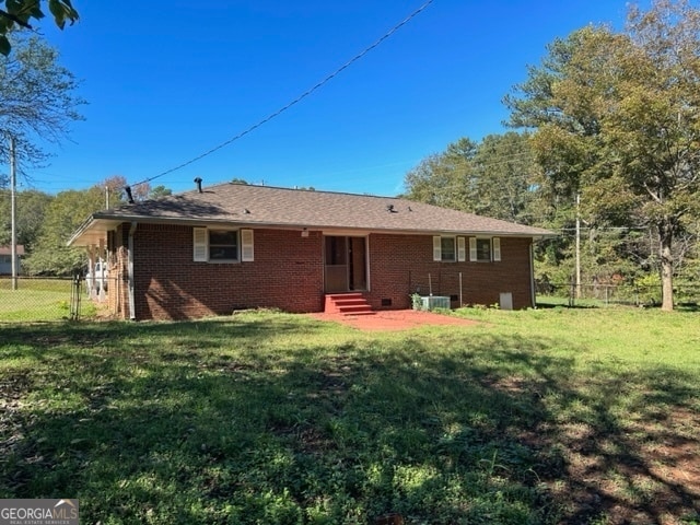 back of house featuring a yard and central AC unit